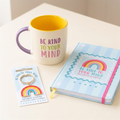 Be Kind to Your Mind gift set showing the cream mug, blue A5 journal and rainbow keyring; included citrine pen not pictured.