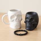 Midnight Skulls gift set with black obsidian skull bracelet, matt black skull oil burner and matte white skull mug.